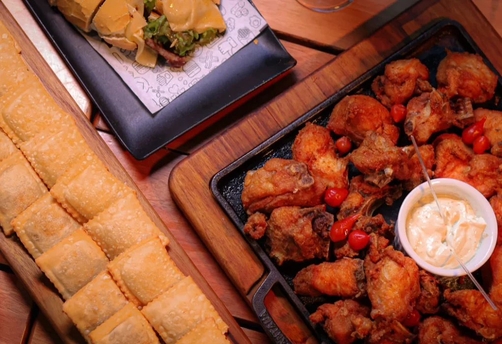 Porque a comida de boteco é tão popular no Brasil? Mesa com petiscos populares